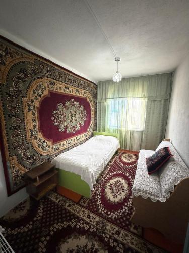 a bedroom with a bed and a large rug at Baburs guest house in Orgochor