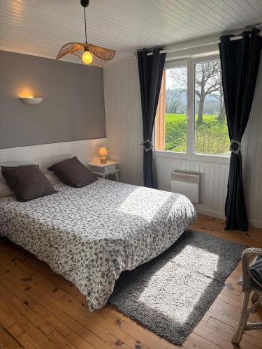 a bedroom with a bed and a large window at Gites de la Haie in Plouégat-Moysan