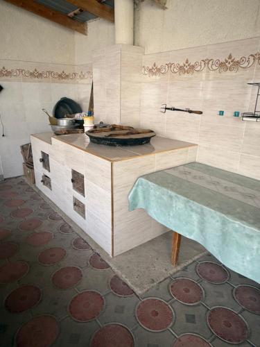 a kitchen with a counter top and a table at Baburs guest house in Orgochor