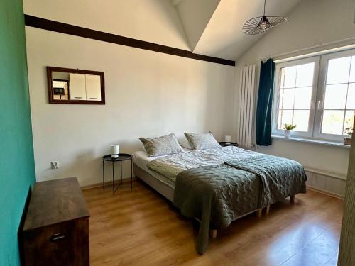 a bedroom with a bed and two windows at Główna Apartamenty Nad Nogatem in Malbork