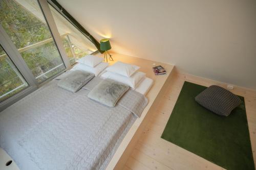 a bedroom with a white bed with pillows and a window at Fain in Bélapátfalva