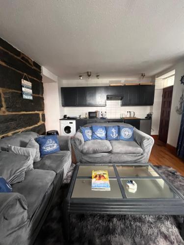 a living room with two couches and a table at Apartment Porthmadog harbourside fantastic estuary views Great spot with parking in Porthmadog