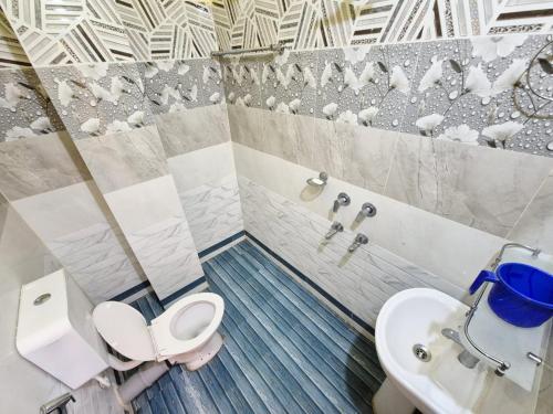 a bathroom with a toilet and a sink at Nmck Homestay in Guwahati