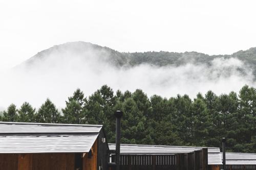 a pile of fog in front of a mountain with trees at Earthboat Minakami Hodaigi in Minakami