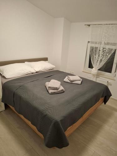 a bedroom with a bed with two towels on it at Apartmani Pavic in Kustići