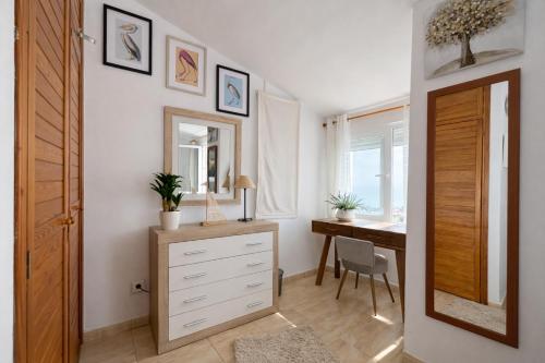 a bedroom with a dresser and a desk and a mirror at Luxury House - Montesol ALBERT VILLAS in Alcossebre
