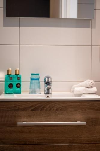 a bathroom counter with two bottles of soap and towels at Hotel Bergrust in Bemelen