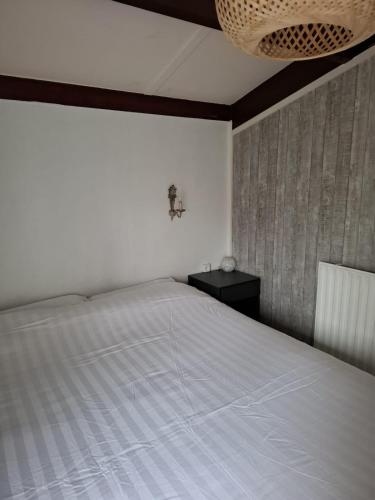 a bedroom with a large white bed and a table at Villa Rosa in Andijk