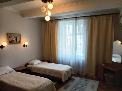 a hotel room with two beds and a window at Chisinau Hotel in Chişinău