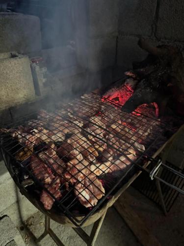a bunch of meat cooking on a grill at Camping Koman in Koman