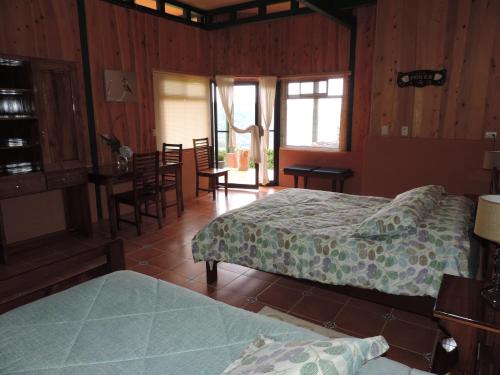 Santa María的住宿－Quinta Galeon Lodge，一间卧室配有两张床和一张桌子及椅子