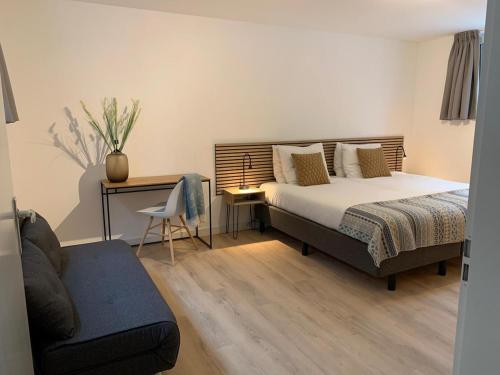 a bedroom with a bed and a chair and a desk at Villa Veluwe in Putten
