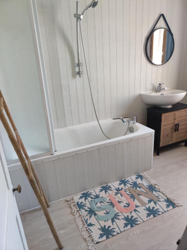 a bathroom with a bath tub and a sink at L Atelier de papa in Dargnies