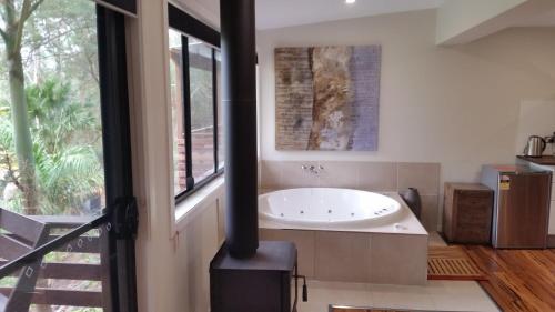 a bathroom with a bath tub and a window at Alaya Ascend in Eudlo