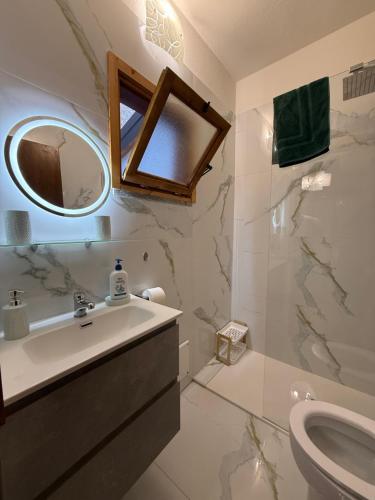 a bathroom with a sink and a mirror and a toilet at Casa vacanze by Michele in Verbania