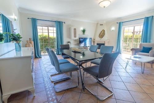 a dining room with a glass table and chairs at Villa Tulipa by Algarve Holidays in Albufeira