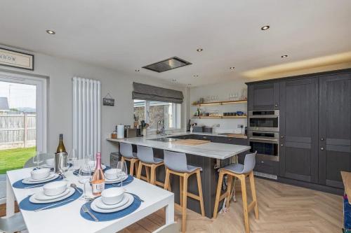 a kitchen with a table and chairs and a counter top at Family-Friendly Retreat between Beach & Mountains in Tremadoc