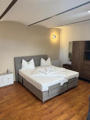a bedroom with a large bed with white sheets at Urlaubsapartment am Silbersee in Villach
