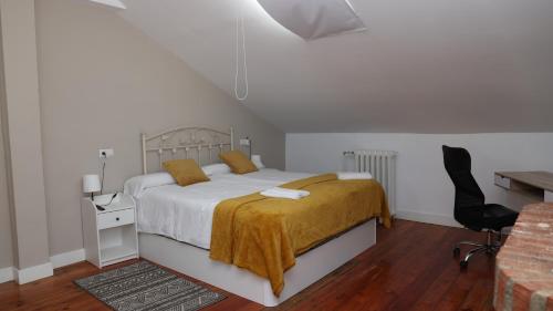a bedroom with a bed with a yellow blanket on it at Casa Vizcaya, Casa rural para grupos de hasta 20 personas en Lanestosa, ideal para reuniones y celebraciones tranquilas in Lanestosa