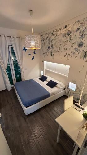 a bedroom with a bed with blue sheets and a table at CIVICO 29 in Pompei