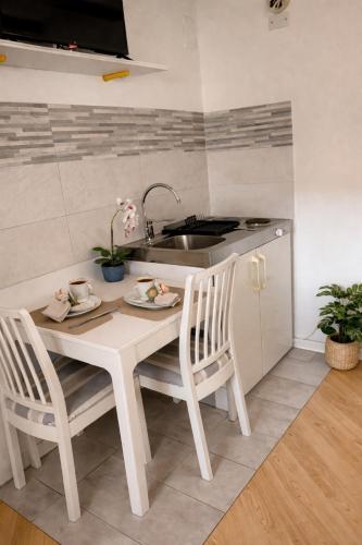 a kitchen with a table and chairs and a sink at Monolocale in casa del 700 - Trento in Belvedere