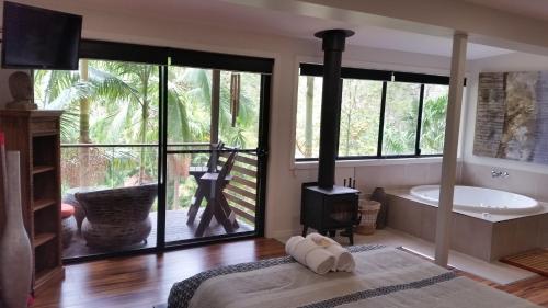a bedroom with a bath tub and a stove at Alaya Ascend in Eudlo