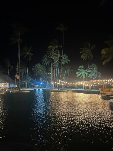 a night view of a resort with palm trees and lights at Antonio Beach in Uroa