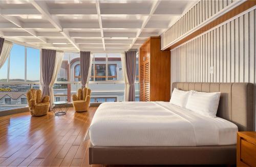 a bedroom with a bed and a large window at Cát Tường Hotel in Da Lat