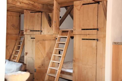 a bunk bed with doors and ladders in a room at Scholtenhoes in Hezingen