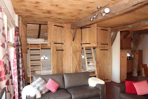 a living room with a couch and two bunk beds at Scholtenhoes in Hezingen