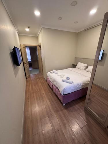 a small bedroom with a bed and a television at RENOVA hOTEL FATİH in Istanbul