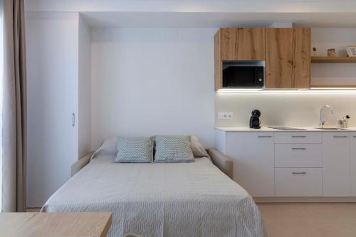 a small bedroom with a bed and a kitchen at Apartamentos Armonia Peñíscola in Peniscola