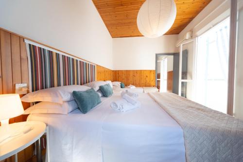 a large white bed with towels on top of it at LUDO Holiday House in Riccione