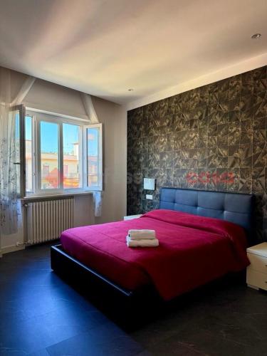 a bedroom with a large red bed with a red blanket at Attico vista mare in Gaeta