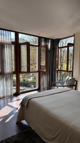 a bedroom with a large bed and large windows at Aguas de Ibias in Cecos
