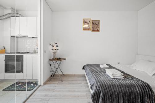 a white bedroom with a bed and a glass wall at FLH - Cozy Heaven in Chiajna