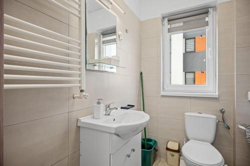 a white bathroom with a toilet and a sink at FLH - Cozy Heaven in Chiajna