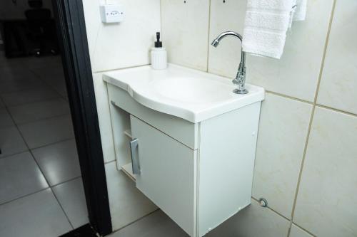 a bathroom with a white sink and a mirror at Quitinete inteligente Centro da Cidade Unidade 1 in Presidente Prudente