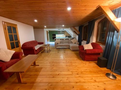 a living room with red chairs and a couch at Hunters Lodge in Liptovská Lúžna
