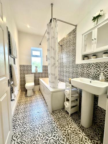a bathroom with a tub and a toilet and a sink at Newcastle Pet friendly 1 bed drive garden 10m city in Kenton