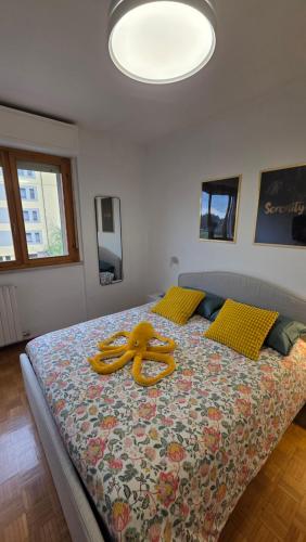 a large bed with a yellow object on it at La Casa di Draf Appartamento Humanitas IEO Forum in Rozzano