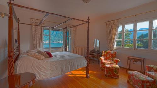 a bedroom with a canopy bed and a table and chairs at Villa Regina in Sala Comacina