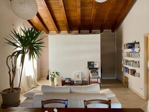 a living room with white couches and a potted plant at Agriturismo Ca' Cristane in Rivoli Veronese