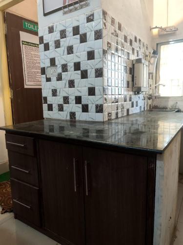 a counter in a kitchen with a tile wall at Green bell male dormitory in Bhopal