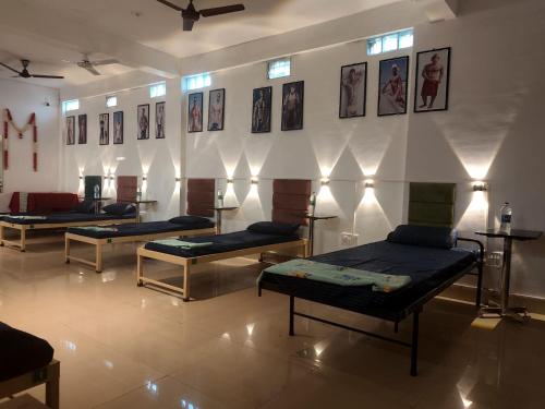 a room with four beds and pictures on the wall at Green bell male dormitory in Bhopal