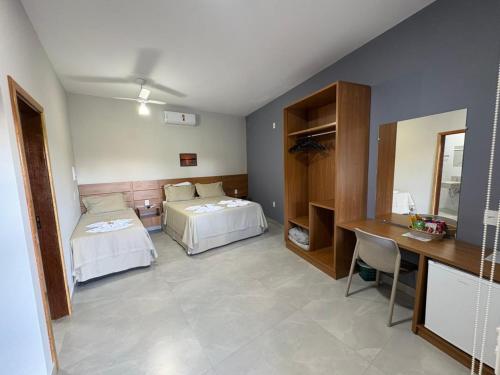 a room with two beds and a desk in it at Hotel Castelo do Lago in Fama