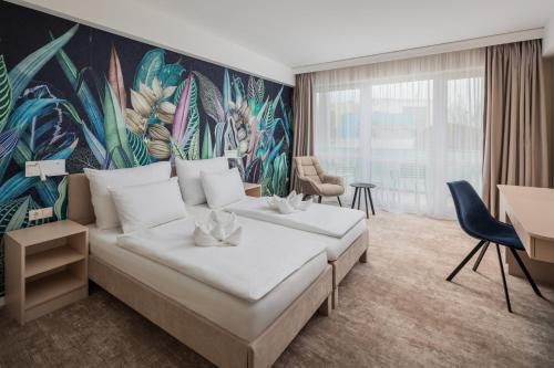ein Schlafzimmer mit einem großen Bett und einem Wandgemälde in der Unterkunft Hotel Atlantis Wellness & Conference in Hajdúszoboszló