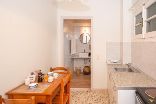 a small kitchen with a table and a sink at Elves Studios& Apartment's SIDARI in Sidari