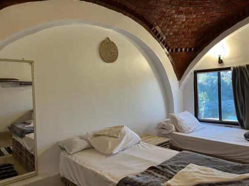 a room with two beds and a mirror in it at Turia Hotel in Aswan