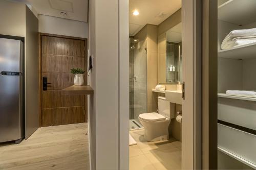 a bathroom with a toilet and a walk in shower at WELL Residences - By AVA Rentals in Asunción